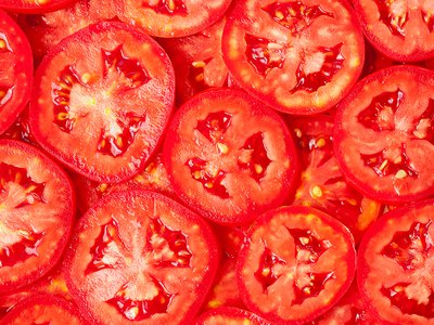 Image of many red tomato slices layred on top of each other
