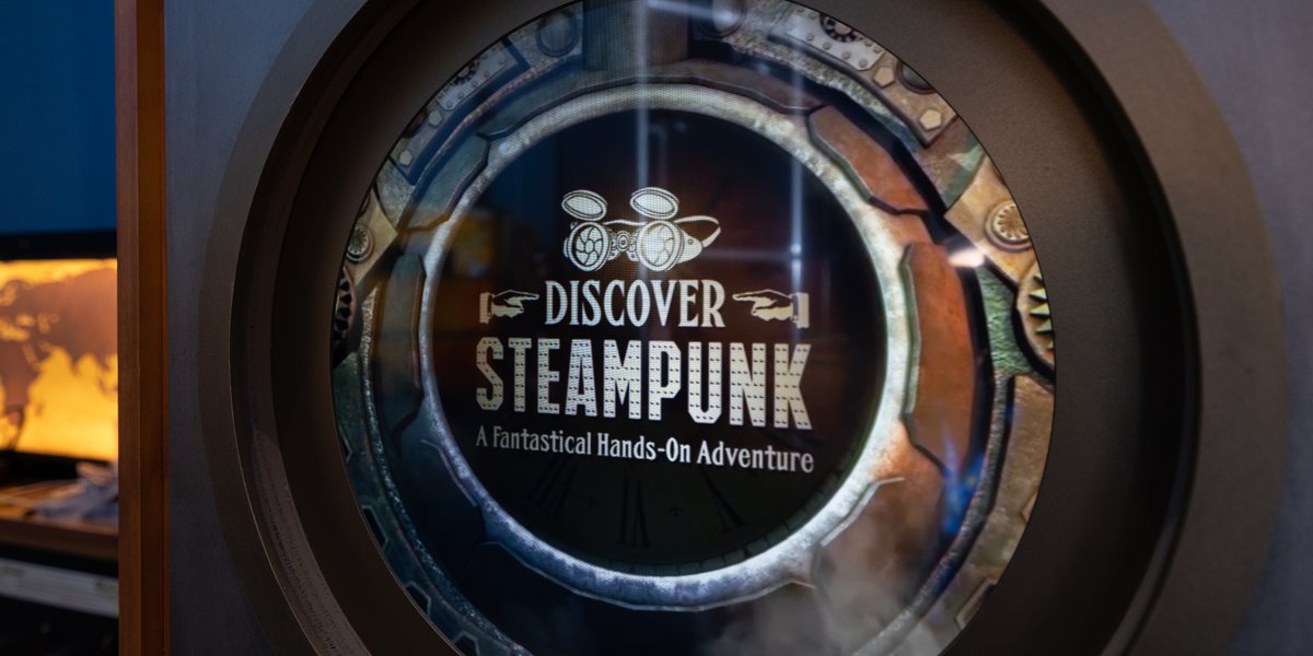 A photograph of a decorative sign at the Virginia Aquarium for the Discover Steampunk exhibit. The sign reads "Discover Steampunk: A Fantastical Hands-On Adventure