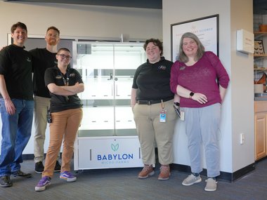 Group of people posing in front of a hydroponic vertical farming unit from Babylon Micro-Farms.jpg