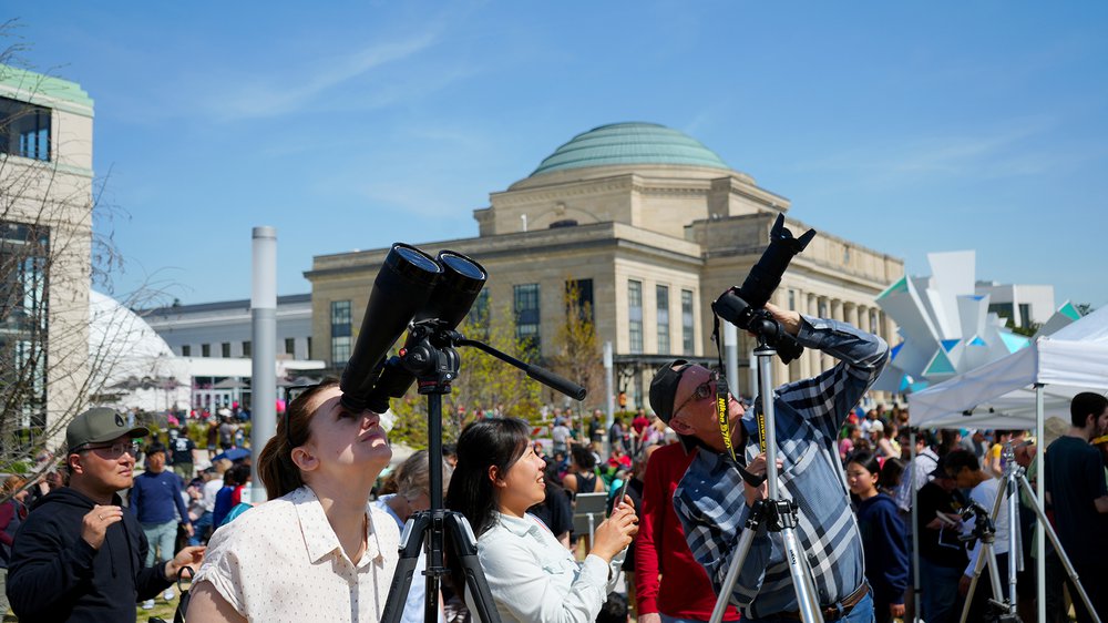 Community members viewing the solar eclipse through telescopes on the Green at the Science Museum of VirginiaJPG