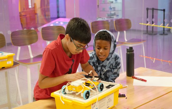 two young boys in the Forge working on a motorized car.jpg