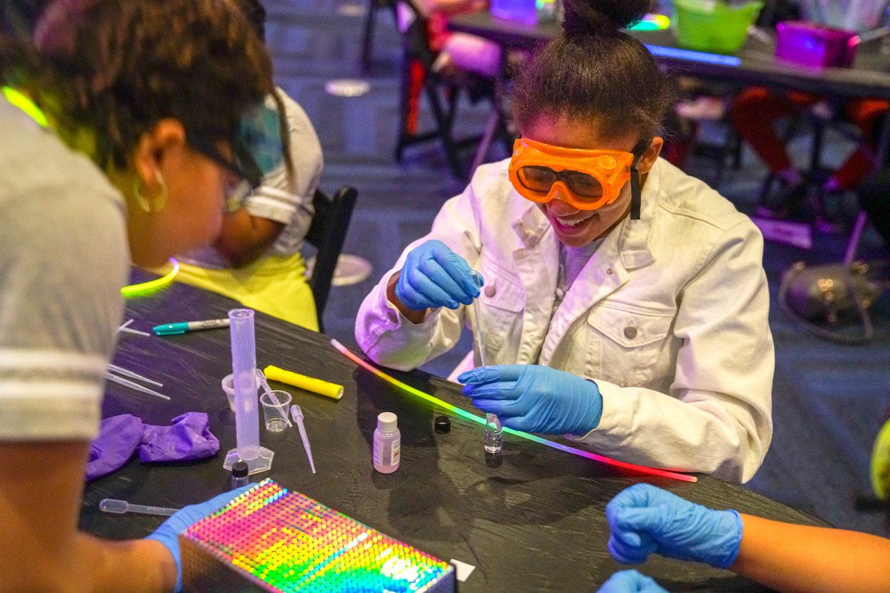 Girls doing a glowing experiment.