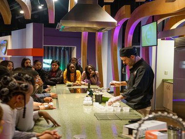 Group of students surround a educator in the Boost Kitchen.jpg