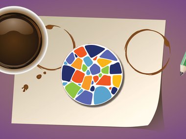 cup of coffee sits next to a coaster made of colorful mosaic tiles.