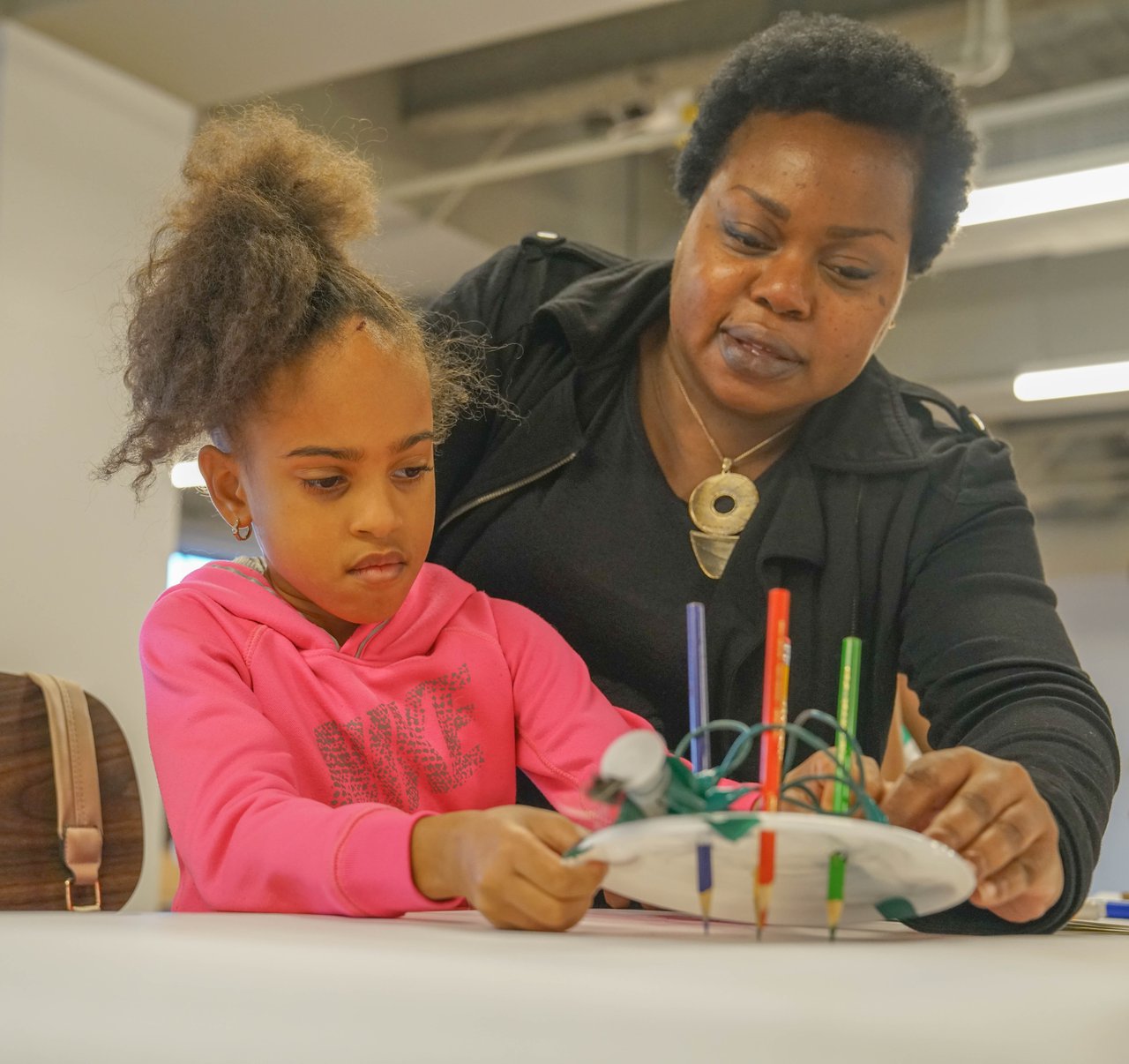 A child and an adult observing a creation.