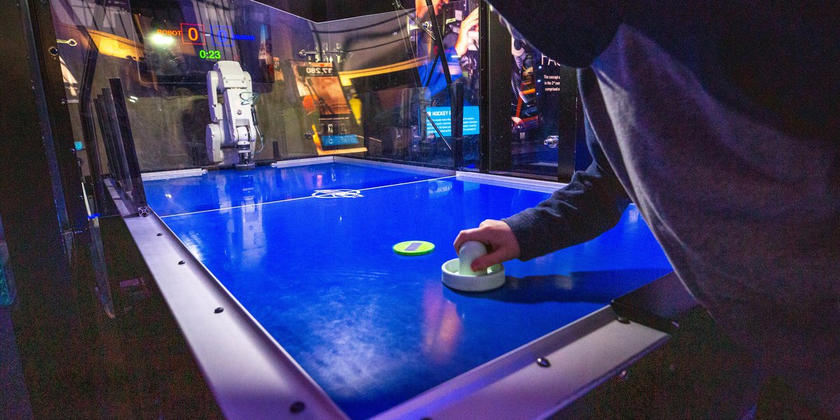 Guest playing the air hockey robot in Speed exhibition.