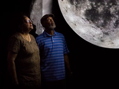 Guests look at the moon while at Science on a Sphere.