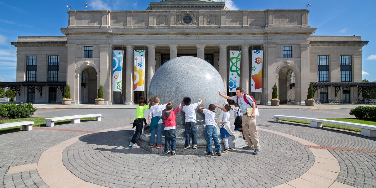 Group of kids touching the Kugel ball.
