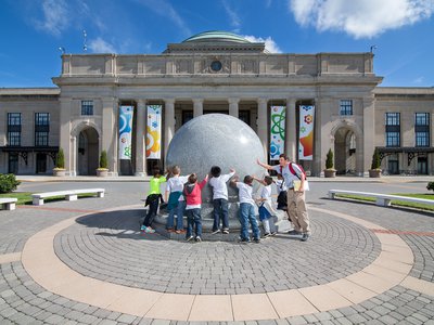 Group of kids touching the Kugel ball.