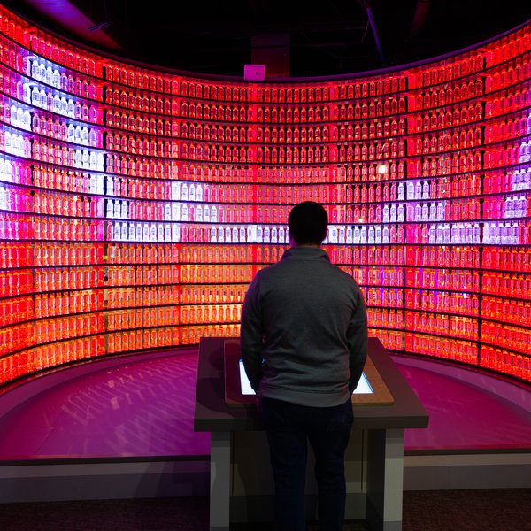 A guest using the water bottle wall in the Boost exhibition.