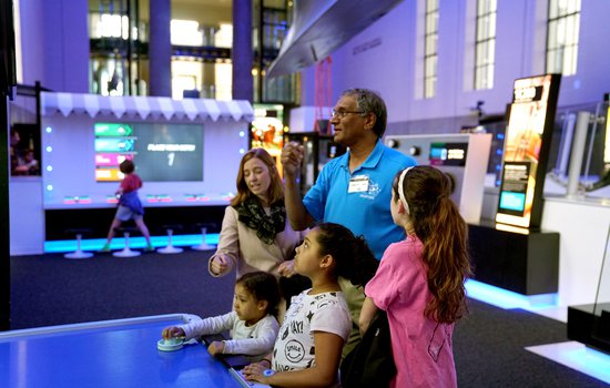 A volunteer and guests in the Speed exhibition.