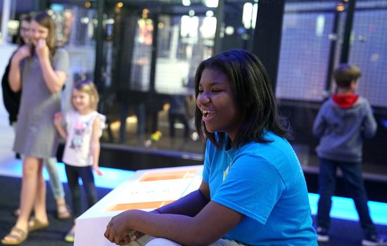 Teen volunteer assists guests in the Science Museum's Speed exhibition.