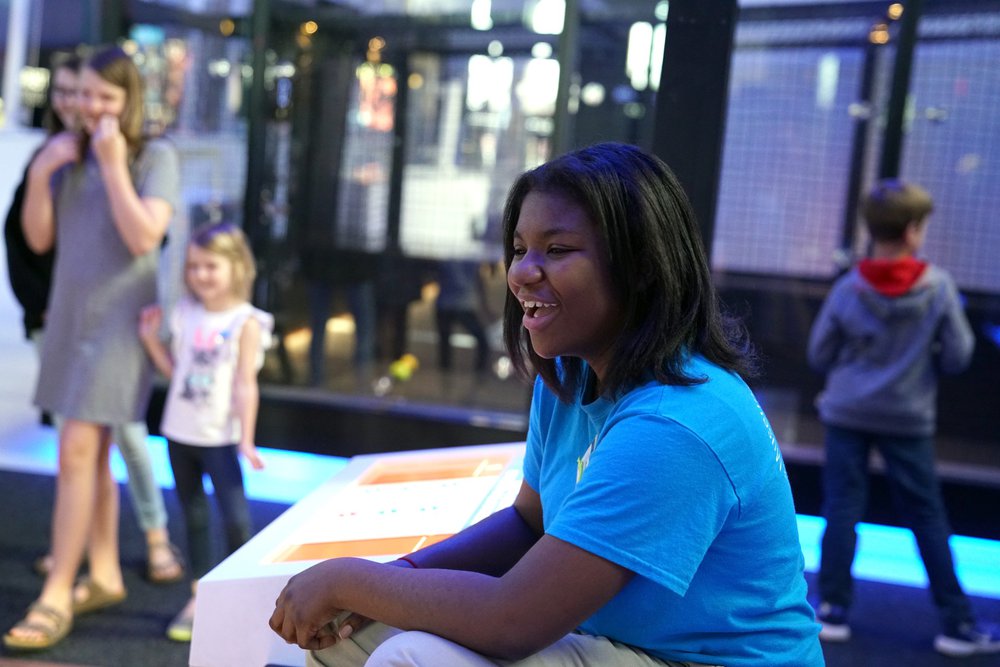 Teen volunteer assists guests in the Science Museum's Speed exhibition.