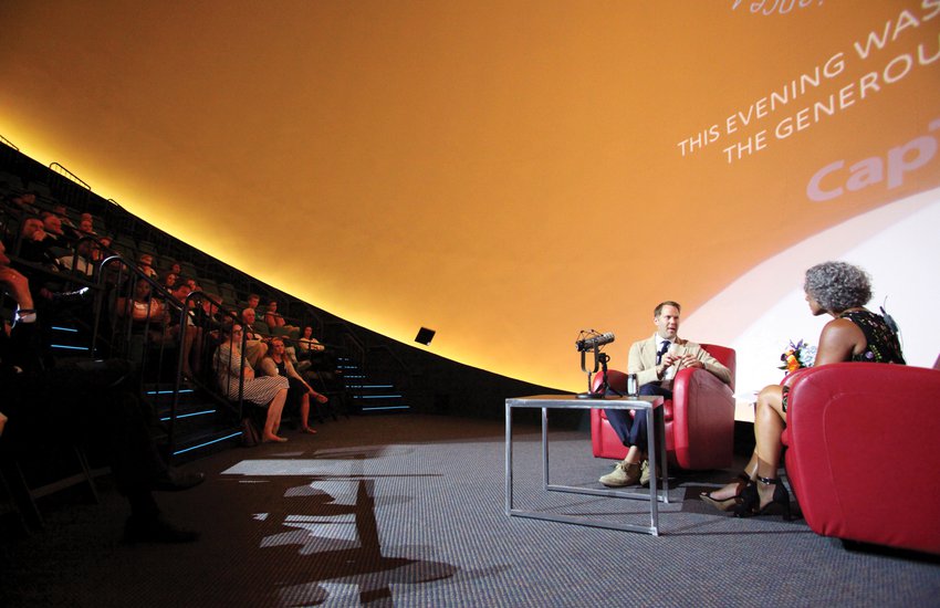 Two people sitting in chairs conducting an interview in The Dome