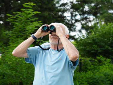 senior using binoculars to watch birds.jpg