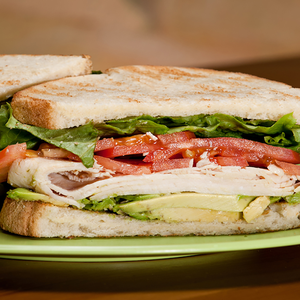 half of a turkey sandwich with lettuce and tomato