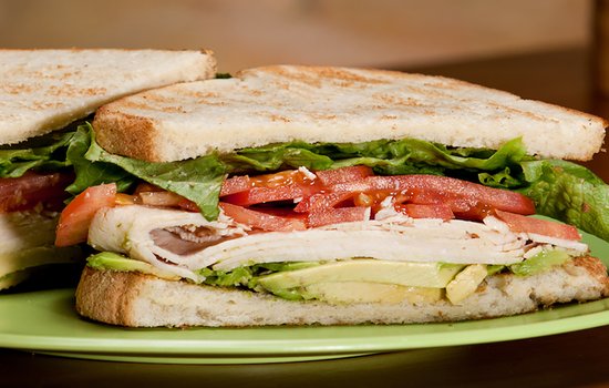 half of a turkey sandwich with lettuce and tomato