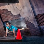 girl crawling out of a hole in a building that appears to be on fire.jpg