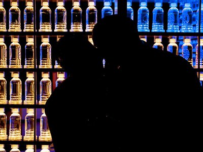 silhouette of a bride and groom in front of the water bottle wall in Boost .jpg