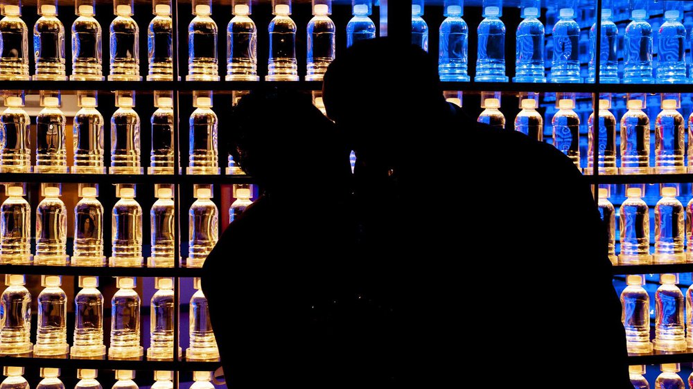 silhouette of a bride and groom in front of the water bottle wall in Boost .jpg