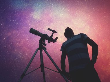 A person with a telescope looking at stars.
