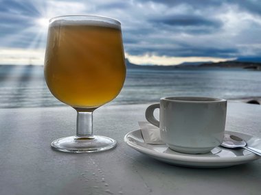 beer and cup of coffee with ocean views in the back ground.jpg