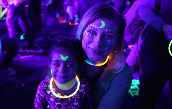 Image of family enjoying black light activities at the Glow event