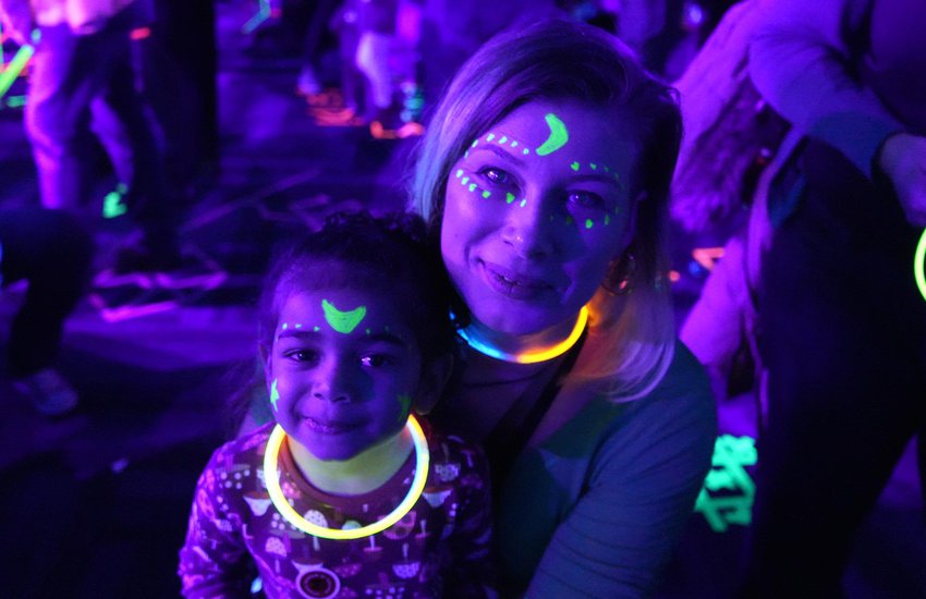 Image of family enjoying black light activities at the Glow event