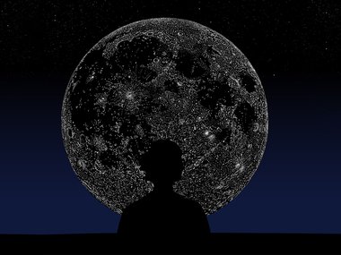 A person's silhouette in front of the moon.