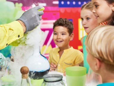 Kids crowded around a science experiment.