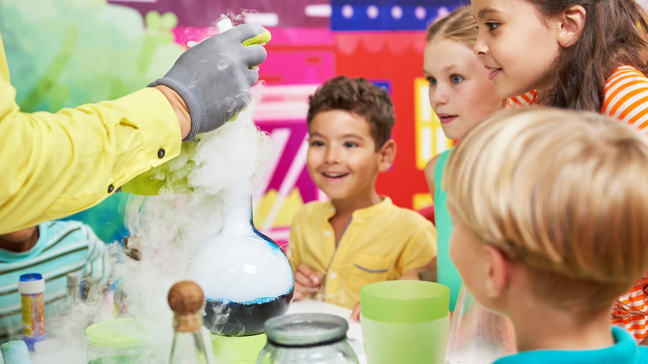 Kids crowded around a science experiment.