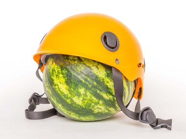 a yellow helmet sits on top of a watermelon